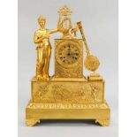 Empire-Pendule, 1. H. 19. Jh., feuervergoldet, stehende Dame an einer Lyra, daneben ein