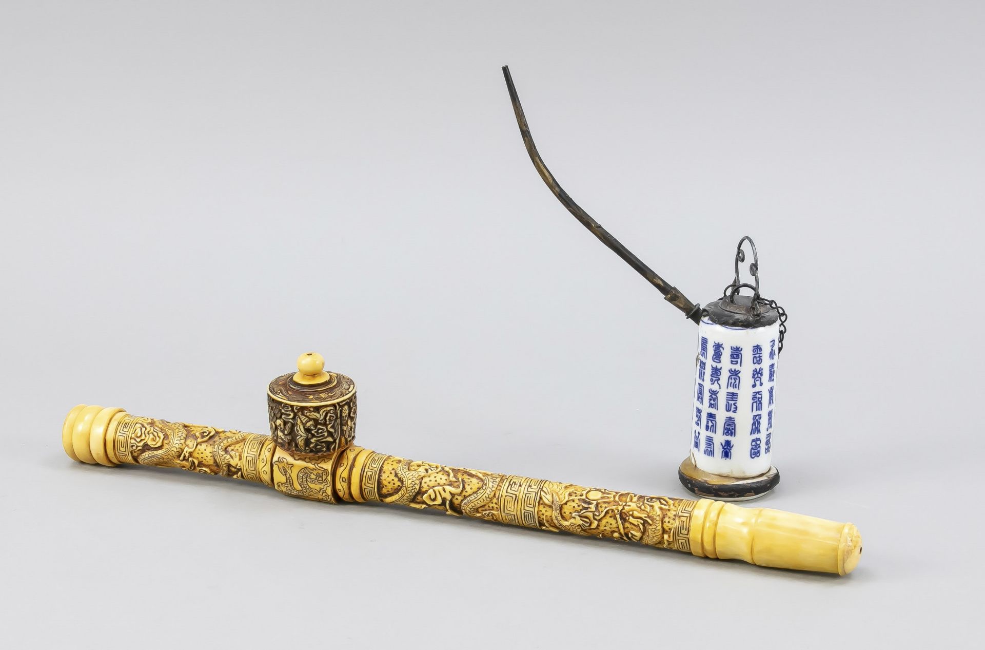 2 opium pipes, China, 19th/20th c. 1 x carved bone (l. 38 cm), 1 x porcelain with cobalt blue