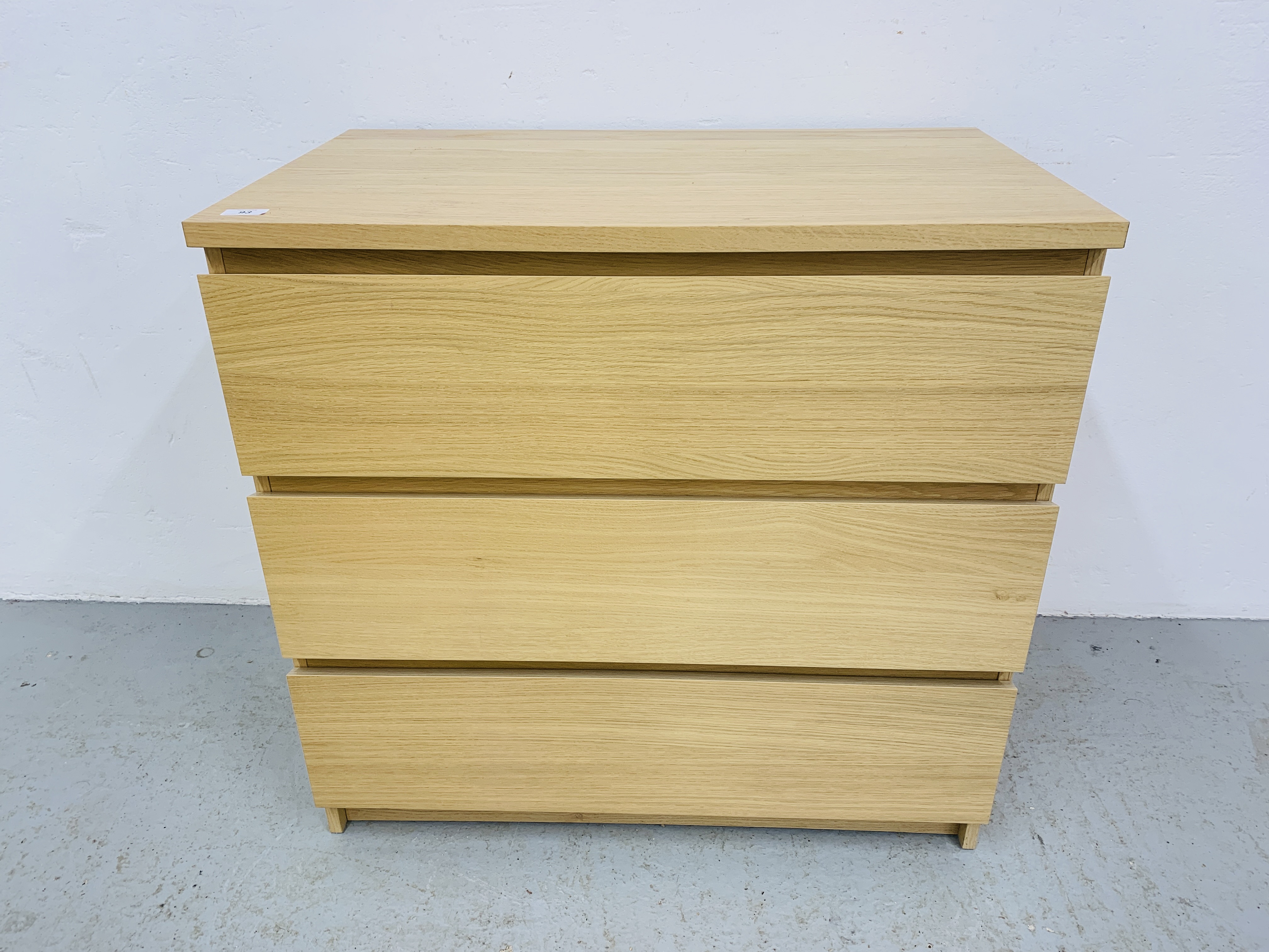 A MODERN LIGHT OAK FINISH THREE DRAWER CHEST - WIDTH 81cm. HEIGHT 78cm.