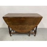 A SOLID OAK GATELEG DINING TABLE WITH TURNED SUPPORTS AND OVAL TOP, WIDTH 106CM,