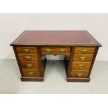 AN EDWARDIAN MAHOGANY NINE DRAWER KNEEHOLE DESK WITH BURGANDY TOOLED LEATHER TOP