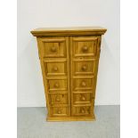 A HONEY PINE TWO DOOR STORAGE CABINET WITH SHELVED INTERIOR. W 53CM. H 93CM. D 21CM.