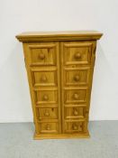 A HONEY PINE TWO DOOR STORAGE CABINET WITH SHELVED INTERIOR. W 53CM. H 93CM. D 21CM.