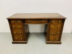 An Edwardian mahogany single piece nine drawer pedestal desk with inlaid tan leather top,