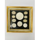 A framed display of ten Grand Tour plaster medallions,