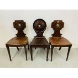 A pair of mahogany George III hall chairs along with a single mahogany hall chair with circular