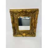 A HEAVILY GILT DECORATED WALL MIRROR 45CM X 40CM.