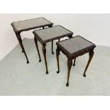 A NEST OF MAHOGANY FINISH TABLES WITH GLASS INSERTS