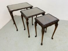 A NEST OF MAHOGANY FINISH TABLES WITH GLASS INSERTS