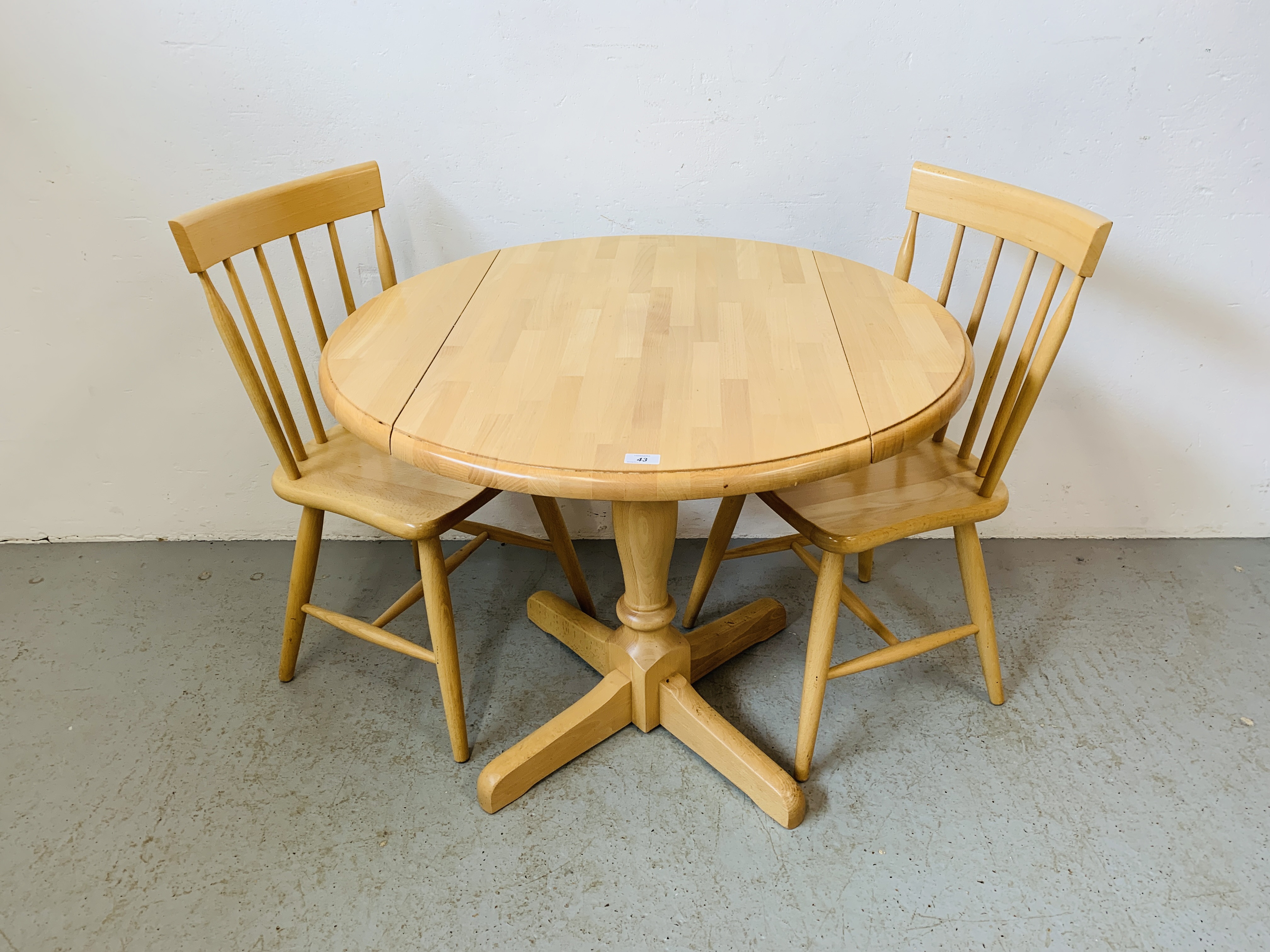 A CIRCULAR DROP SIDE BEECH WOOD KITCHEN TABLE WITH FOUR CHAIRS