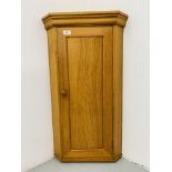A SMALL SOLID OAK WALL HANGING CORNER CABINET WITH SHELVED INTERIOR. H 84cm. W 48cm.