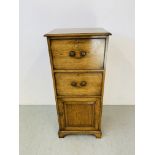 AN OAK FILING CABINET, TWO DRAWERS WITH CUPBOARD BELOW. H 127cm. W 54cm. D 41cm.