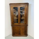 A REPRODUCTION STANDING OAK AND PINE CORNER CUPBOARD, THE UPPER SECTION GLAZED. WIDTH 104cm.