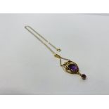 AN AMETHYST PENDANT SET IN 9CT GOLD ON A FINE 9CT GOLD CHAIN.