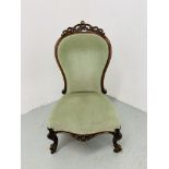 A VICTORIAN MAHOGANY SPOON BACK EASY CHAIR WITH GREEN VELOUR UPHOLSTERY