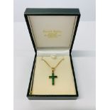 A 9CT GOLD EMERALD CROSS ON CHAIN