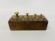A CASE OF BRASS CYLINDRICAL WEIGHTS, RANGING FROM 1KG DOWNWARDS,