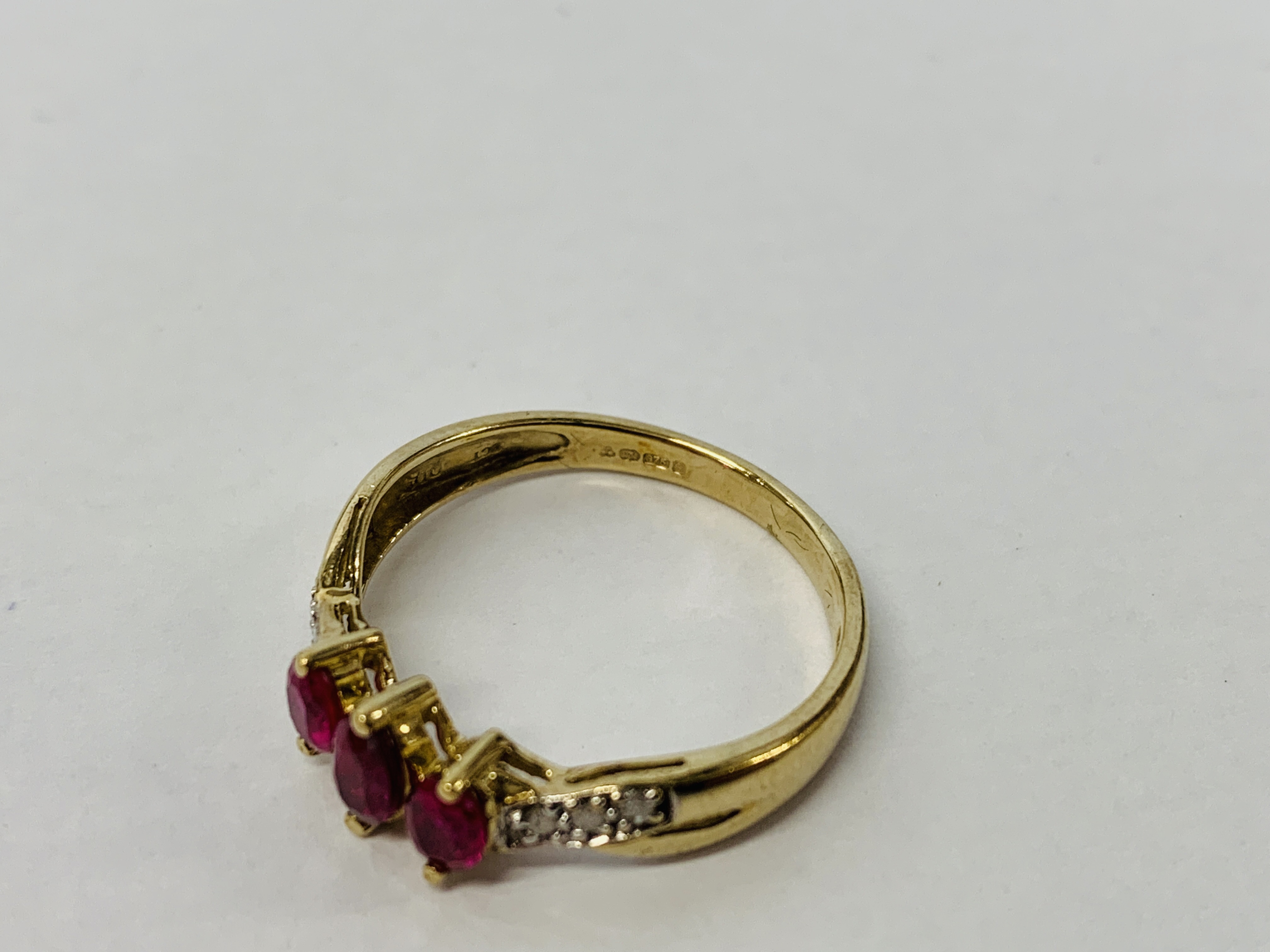 A 9CT GOLD THREE STONE RUBY RING WITH DIAMOND SET SHOULDERS - Image 7 of 8