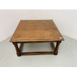 A SOLID OAK ANTIQUED FINISH COFFEE TABLE - W 81CM. D 81CM. H 42CM.