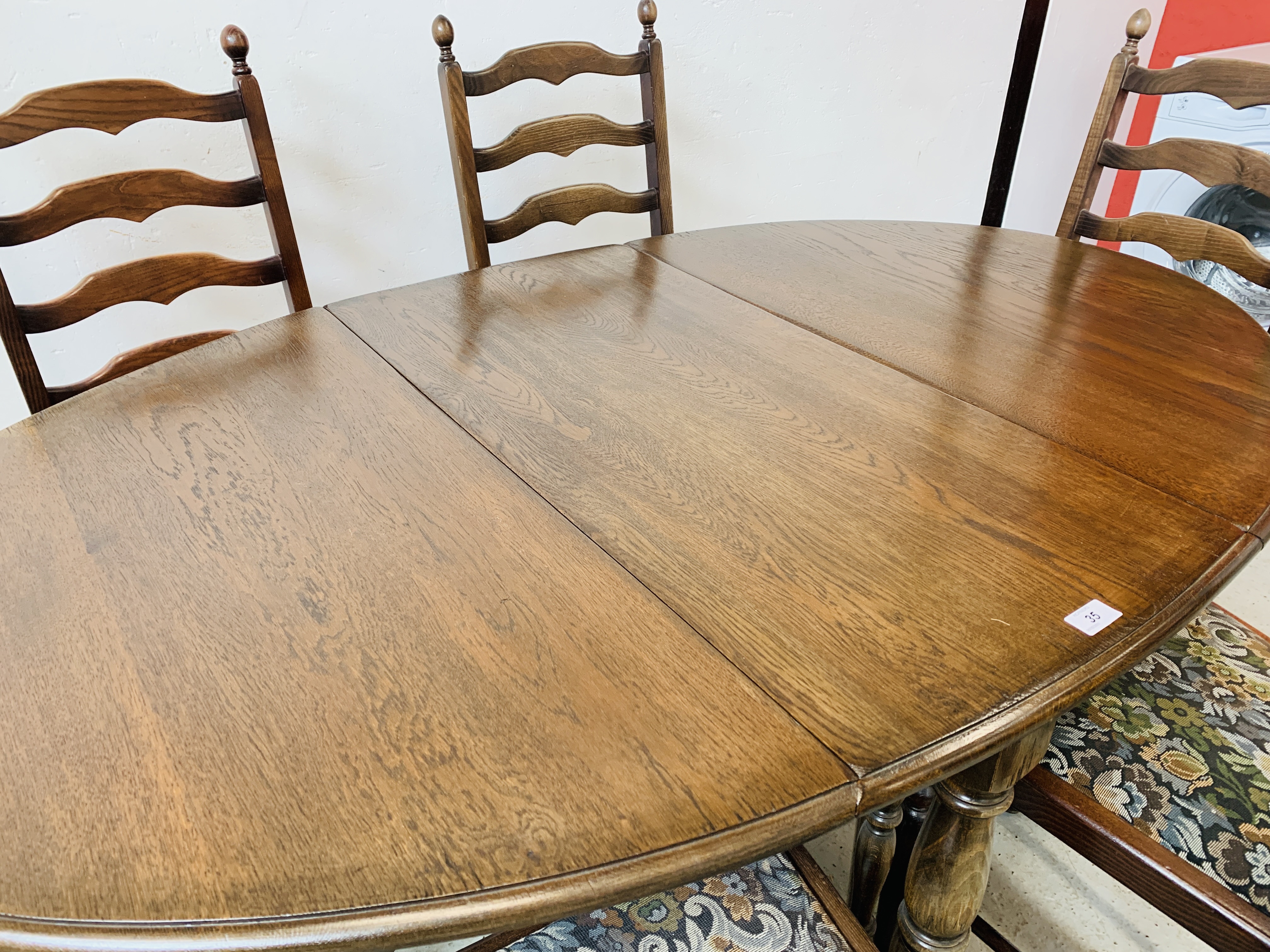 AN OVAL TOP OAK GATELEG DINING TABLE EXTENDED 152 X 91CM ALONG WITH A SET OF SIX LADDER BACK DINING - Image 9 of 12