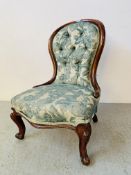 A VICTORIAN MAHOGANY NURSING CHAIR UPHOLSTERED IN GREEN PATTERNED MATERIAL