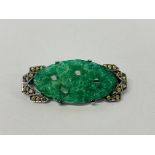 AN ORIENTAL SILVER BROOCH MARKED 935 SET WITH SMALL WHITE STONES AND A CARVED AND PIERCED JADE