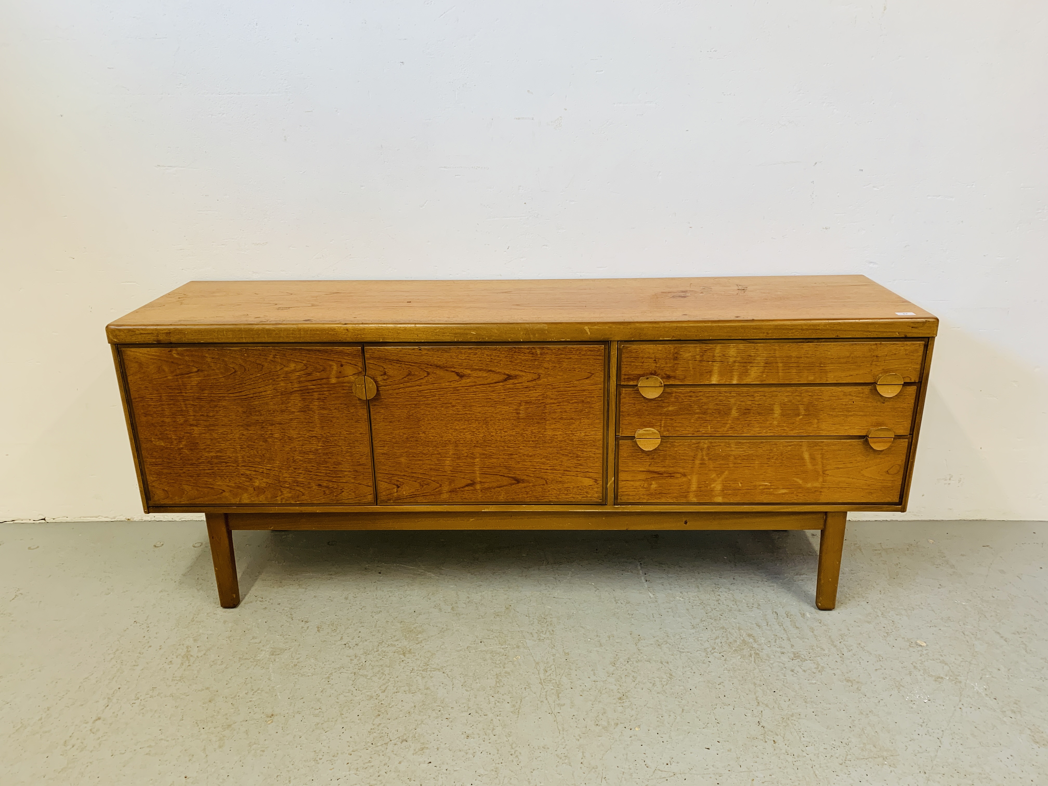 A RETRO TEAK FINISH SIDEBOARD WITH THREE DRAWERS AND TWO CABINET DOORS - LENGTH 184CM. DEPTH 45CM.