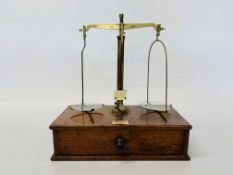 A BRASS BALANCE BY MAW & SONS, ALDERSGATE STREET, LONDON ON MAHOGANY BASE, WIDTH 28.