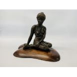 A BRONZED RESIN SCULPTURE OF A SEATED WOMAN BY SONIA DOBBS ON PINE BASE - HEIGHT 33.5 CM.