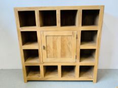 A HARDWOOD ACACIA PIGEON HOLE DISPLAY CABINET WITH CENTRAL CUPBOARD - W 135CM. D 45CM. H 135CM.