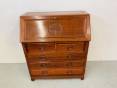 A REPRODUCTION HARDWOOD FIVE DRAWER BUREAU WITH CARVED "LONG LIFE" DESIGN TO FRONT PANEL AND DRAWER