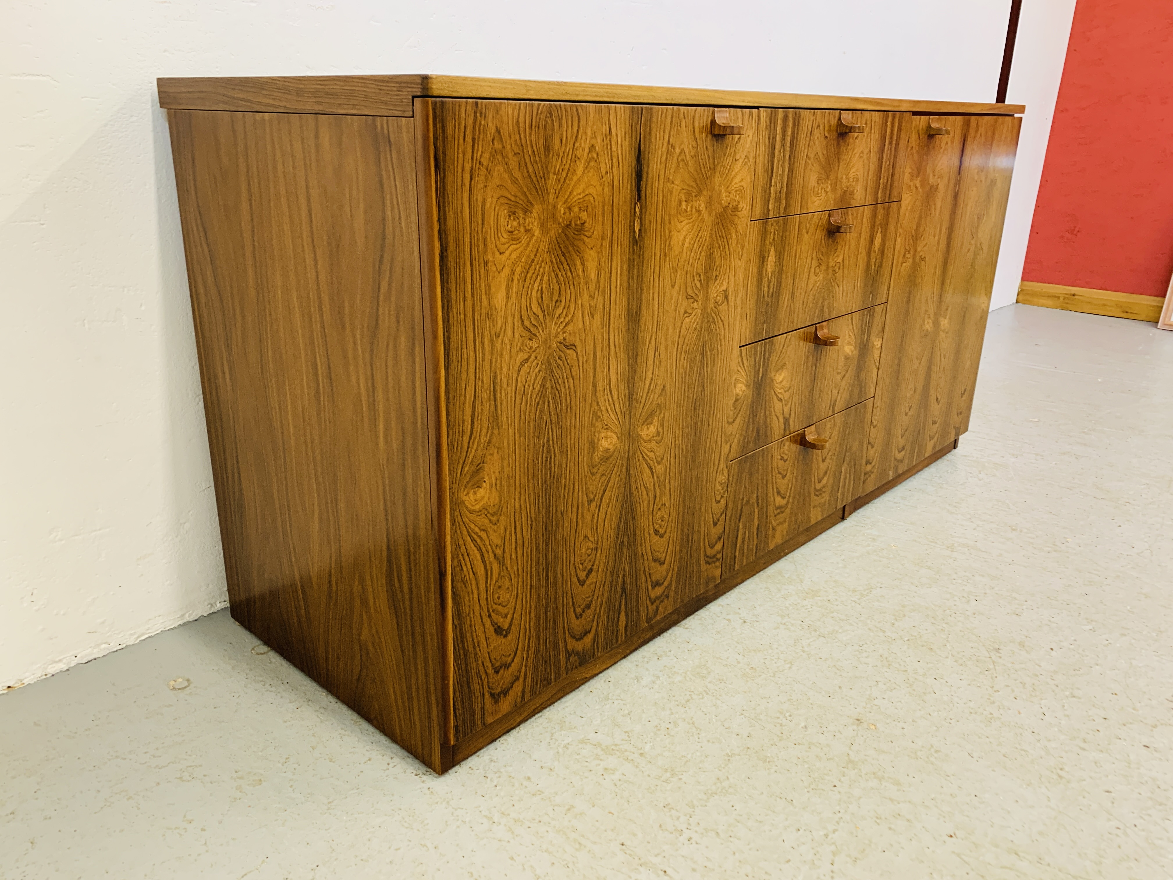 A C20TH BRAZILIAN ROSEWOOD RETRO SIDEBOARD HAVING FOUR CENTRAL DRAWERS FLANKED BY CUPBOARDS TO - Image 7 of 15