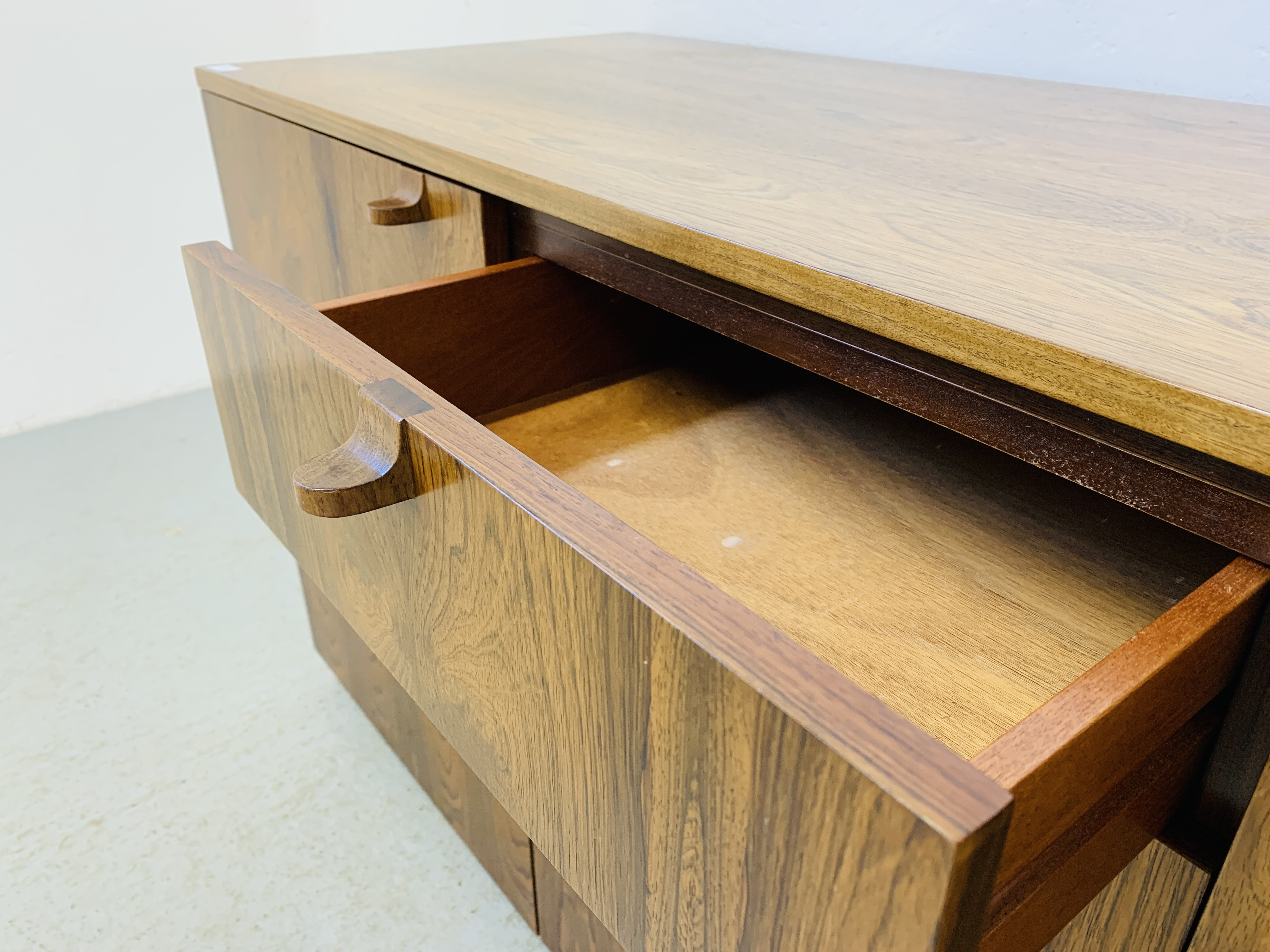 A C20TH BRAZILIAN ROSEWOOD RETRO SIDEBOARD HAVING FOUR CENTRAL DRAWERS FLANKED BY CUPBOARDS TO - Image 12 of 15