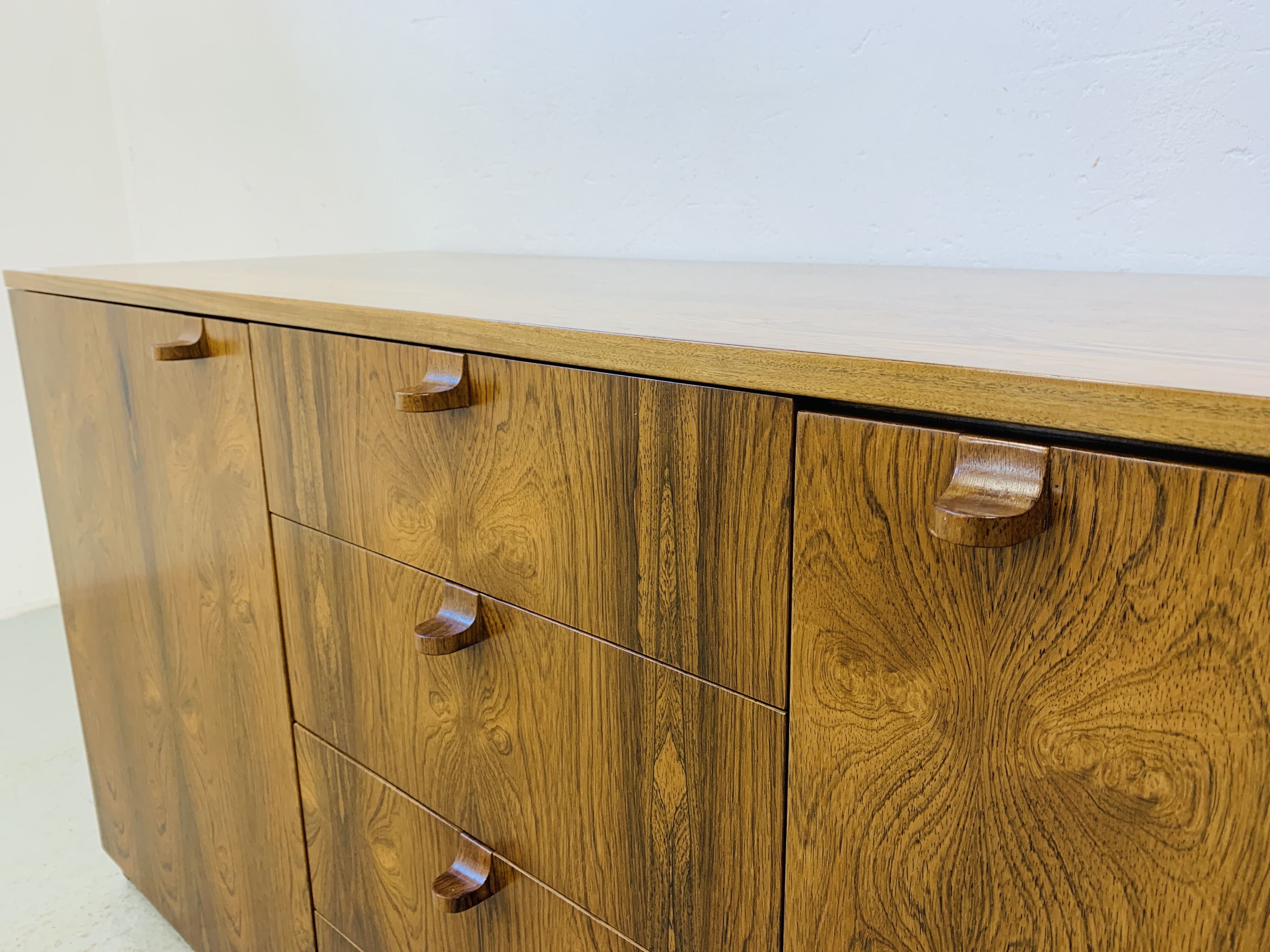 A C20TH BRAZILIAN ROSEWOOD RETRO SIDEBOARD HAVING FOUR CENTRAL DRAWERS FLANKED BY CUPBOARDS TO - Image 11 of 15