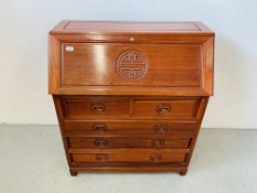 A REPRODUCTION HARDWOOD FIVE DRAWER BUREAU WITH CARVED "LONG LIFE" DESIGN TO FRONT PANEL AND DRAWER