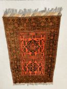 A RED PATTERNED PERSIAN CARPET 197CM X 122CM