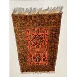 A RED PATTERNED PERSIAN CARPET 197CM X 122CM