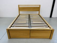 A MODERN LIGHT OAK DOUBLE BEDSTEAD WITH DRAWERS AND SLIDE OUT STANDS TO BASE