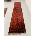 A RED PATTERNED PERSIAN HALL RUNNER 385CM X 80CM