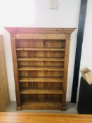 A SOLID WAXED PINE FULL HEIGHT BOOKSHELF - H 198 CM. W 138CM.