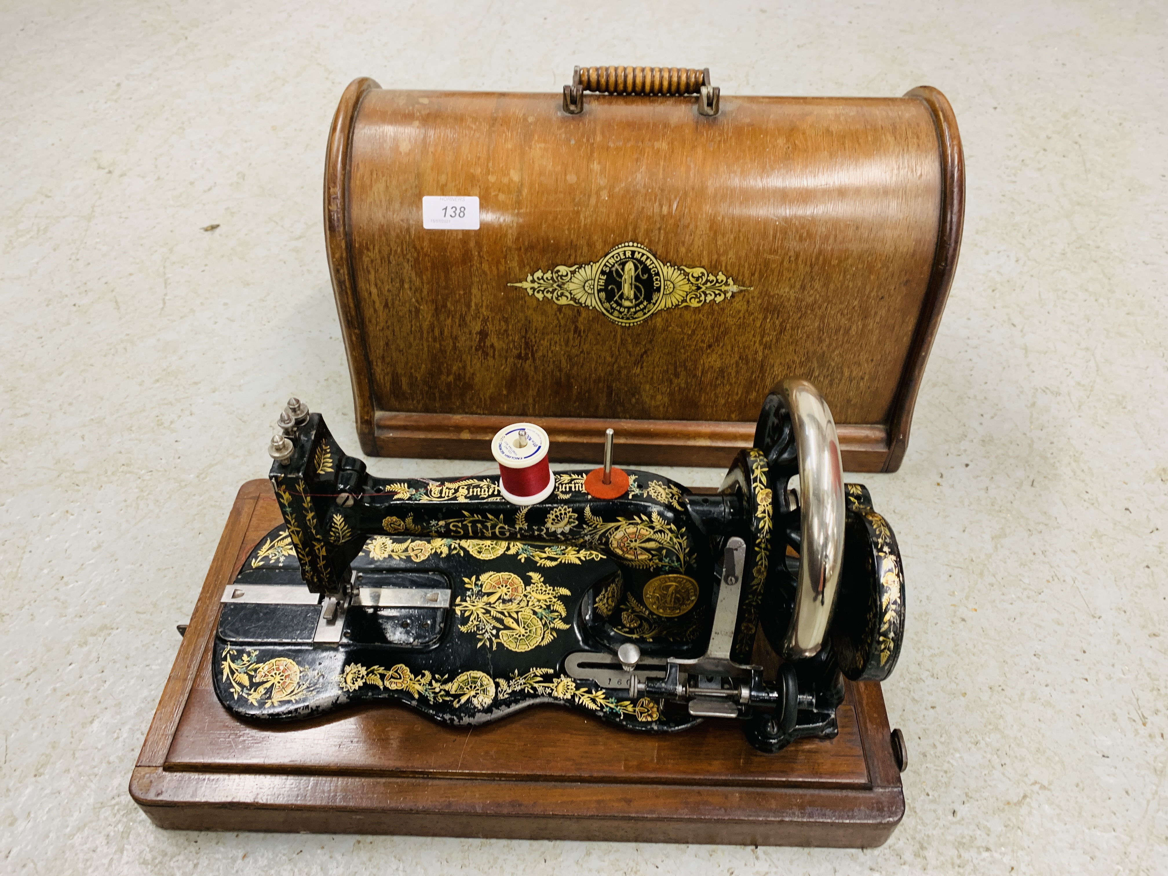 A VINTAGE SINGER GILT DECORATED MANUAL SEWING MACHINE UNDER ORIGINAL DOMED COVER