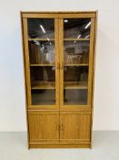 AN OAK FINISH PART GLAZED CABINET WITH CUPBOARD BASE - W 91CM. D 40CM. H 182CM.