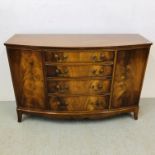 A REPRODUCTION MAHOGANY 4 DRAWER 2 DOOR BOW FRONT SIDEBOARD - W 130CM. D 46CM. H 88CM.