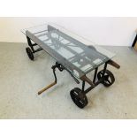A GLASS TOP EXTENDING COFFEE TABLE CONVERTED FROM AN ANTIQUE COOKS RATCHET ACTION SACK BARROW
