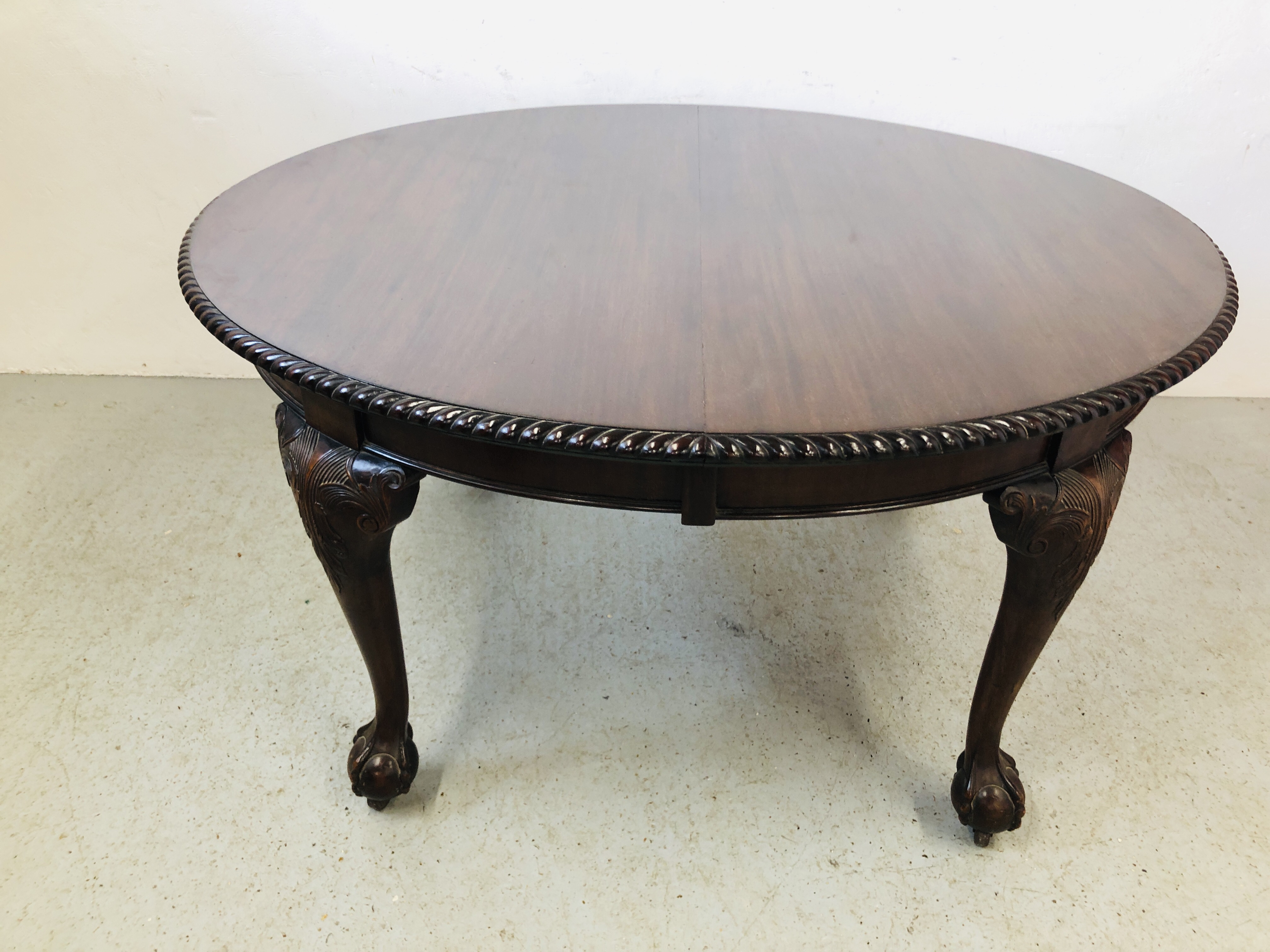 AN EXTENDING MAHOGANY OVAL EXTENDING DINING TABLE ON BALL AND CLAW FEET (2 EXTENSION LEAVES) WIND