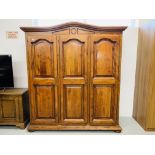 A REPRODUCTION SOLID WOOD TRIPLE WARDROBE WITH PANELLED DOORS AND ARCHED PEDIMENT, WIDTH 186CM,