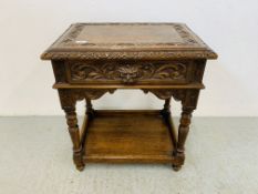 A HEAVILY CARVED OAK TWO TIER SIDE TABLE WITH GREEN MAN DETAIL - W 61CM. D 45CM. H 68CM.