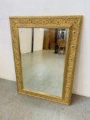 AN ORNATE RECTANGULAR GILT FRAMED BEVELLED WALL MIRROR W 96CM,