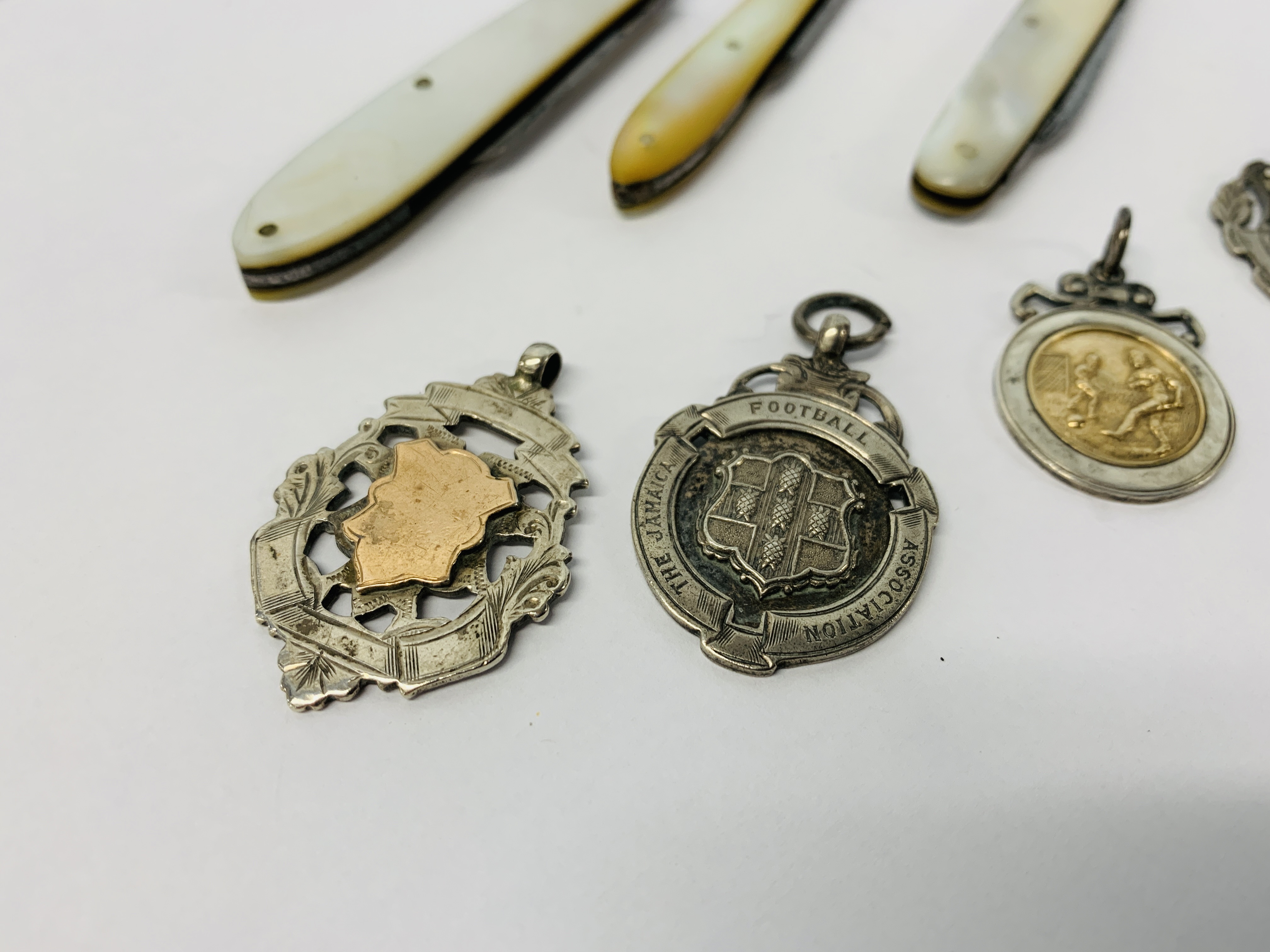 THREE MOTHER OF PEARL HANDLED FRUIT KNIVES AND FOUR SILVER FOOTBALL MEDALS - Image 2 of 6