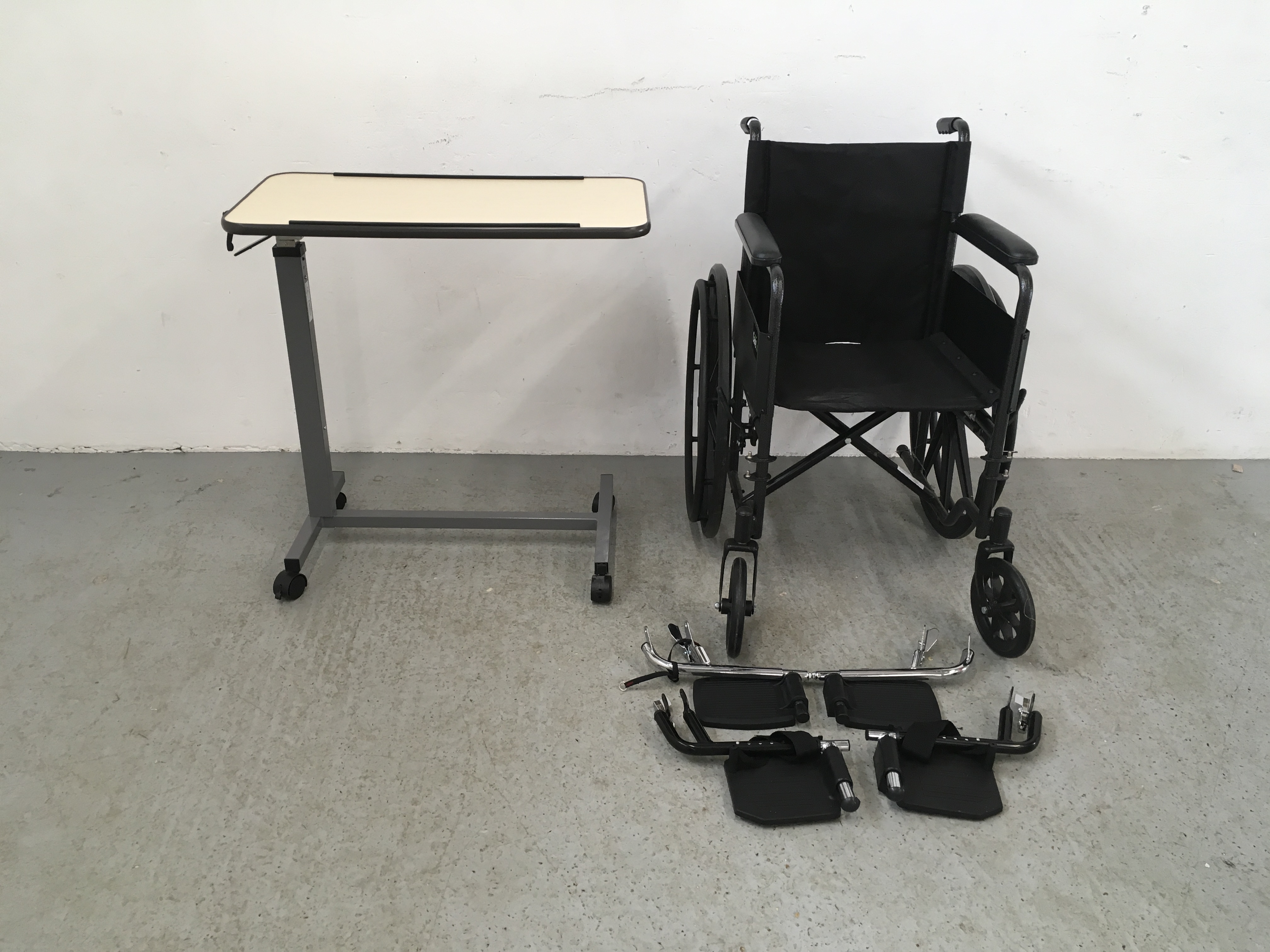 CARE CO WHEEL CHAIR AND FOOT RESTS ALONG WITH A WHEELED BED TRAY